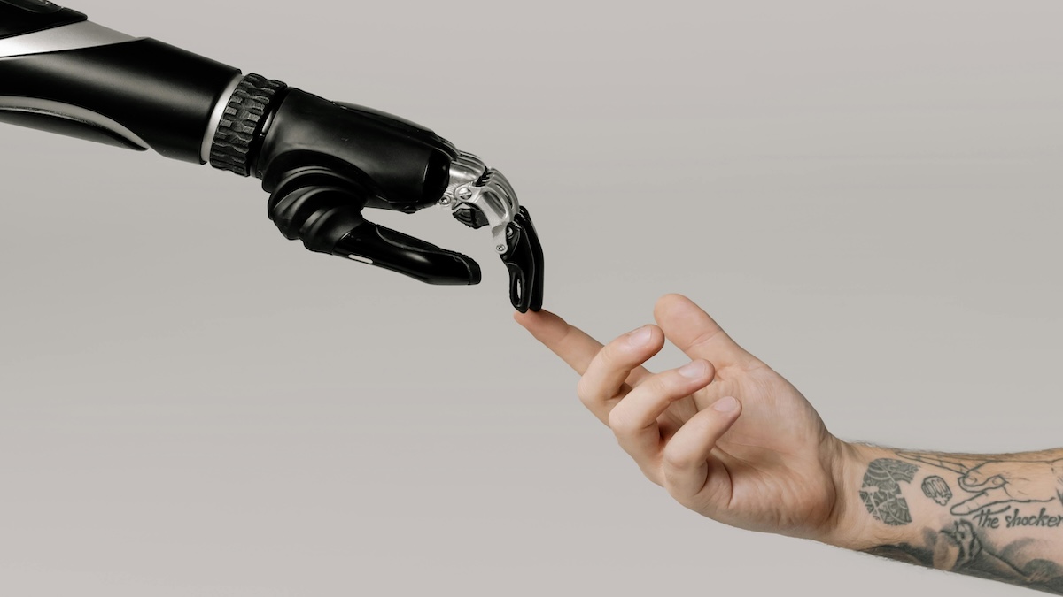 A robotic hand and a human hand reaching toward each other, symbolizing AI-human collaboration in B2B lead nurturing